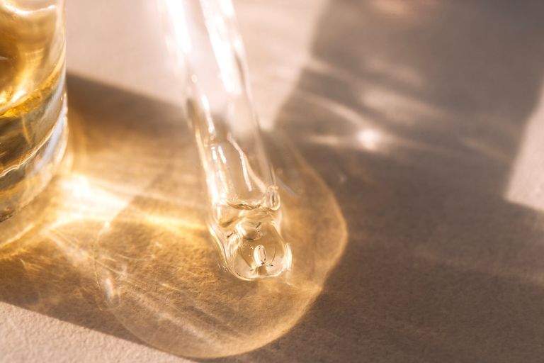 Close-up of a glass pipette with transparent gel with bubbles