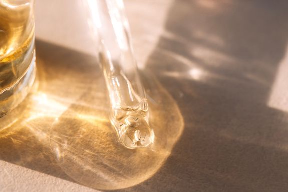 Close-up of a glass pipette with transparent gel with bubbles